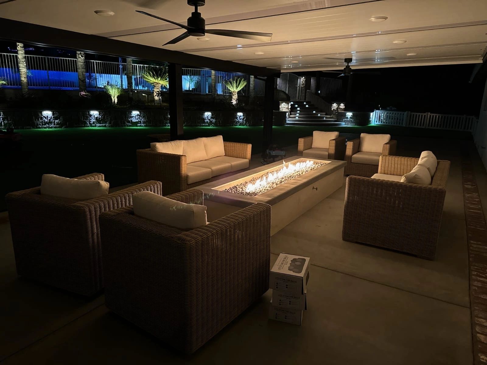 Covered patio seating and fire feature at night